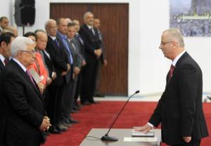 Palestinian Prime Minister Rami Hamdallah (R) is sworn …