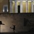 A Greek presidential guard marches past the Monument of the Unknown Soldier in Athens