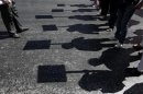 Protesters cast their shadows as they march during an anti-government rally in front of the parliament in Athens