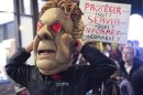 Un manifestante se cubre con una máscara del primer ministro de Quebec