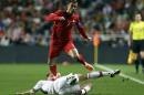 FILE - In this June 7, 2013, file photo, Portugal's Cristiano Ronaldo gets the ball past Russia's Alexei Kozlov, on the ground, during their 2014 World Cup qualifying group F soccer match, at the Luz stadium in Lisbon. (AP Photo/Armando Franca) - SEE FURTHER WORLD CUP CONTENT AT APIMAGES.COM