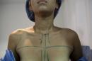 In this Sept, 4, 2014 photo, a patient is prepped for her breast augmentation at the metropolitan outpatient surgery center in Caracas, Venezuela. Doctors say restrictive currency controls that deprive local businesses of the cash to import foreign goods have caused breast implants approved by the U.S. Food and Drug Administration to disappear. It may not be the gravest shortfall facing the socialist South American country, but surgeons say the issue cuts to the psyche of the image-conscious Venezuelan woman. (AP Photo/Ariana Cubillos)