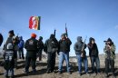 Members of the American Indian Movement stand near the Wounded Knee Massacre Monument, Wednesday, Feb. 27, 2013 in Wounded Knee, S.D. Wednesday marked the 40th anniversary of the start of the 71-day occupation in the village of Wounded Knee on the Pine Ridge Indian Reservation. Hundreds of AIM members and other supporters turned out for a day of ceremonies to commemorate the anniversary of the fatal standoff that drew national attention to the impoverished reservation and the plight of local tribes. (AP Photo/Kristi Eaton)