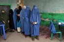 Photo taken on September 7, 2013 shows Afghan women waiting in line to receive voter identification cards in Jalalabad