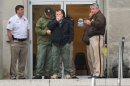 Law enforcement officers wait at the entrance to the Jackson Police Department Thursday, April, 4, 2013, after police say a murder suspect fatally shot detective Eric Smith inside the headquarters. The suspect is also dead. (AP Photo/The Clarion-Ledger, Greg Jenson)