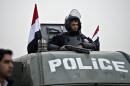 An Egyptian policeman stands guard on the top of an armoured vehicle in Cairo on February 16, 2014