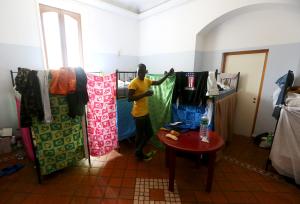 An adolescent migrant stands in his bedroom at an immigration &hellip;