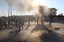 People gather near burning tyres during a demonstration against forces loyal to Syria's President Bashar al-Assad and calling for aid to reach Aleppo near Castello road in Aleppo