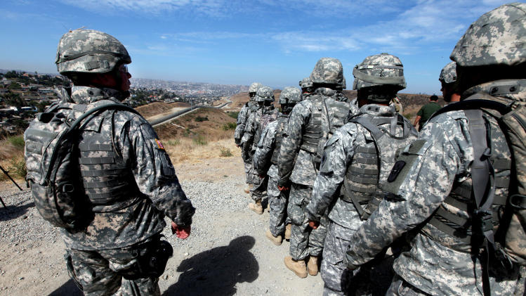 File photo shows National Guard troops standing in formation along the US-Mexico border in San Ysidro, California during a visit by California Gov. Arnold Schwarzenegger on August 18, 2010
