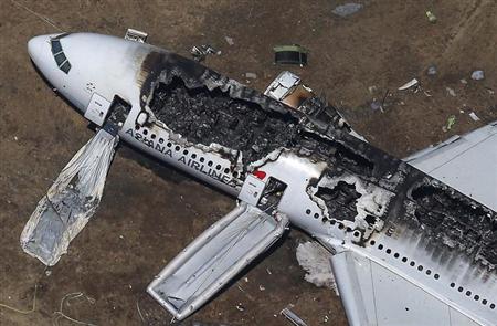Rescue officials stand near an Asiana Airlines Boeing 777 plane after it crashed while landing at San Francisco International Airport in California on July 6, 2013.