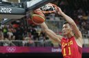 China's Yi Jianlian slams a dunk after getting past Spain's Marc Gasol, left, and Victor Sada, right, during a men's basketball game at the 2012 Summer Olympics, Sunday, July 29, 2012, in London. (AP Photo/Charles Krupa)