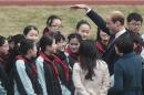 Britain's Prince William gestures to the students as he attends the Premier Skills football coaching event at Nanyang Secondary School in Shanghai, China Tuesday, March 3, 2015. William focused his China trip on promoting links between the countries in football and film Tuesday, watching students kick balls around with Premier League-trained coaches ahead of a movie premiere. (AP Photo) CHINA OUT