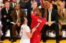 Chris Bosh, de los Miami Heat, busca espacio para dar un pase presionado por Jordan Farmer, de Los Angeles Lakers, en partido de la liga NBA disputado en el Staples Center en Los Angeles, California, el 25 de diciembre de 2013.
