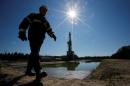 Worker walks past drilling rig at well pad of Rosneft-owned Prirazlomnoye oil field outside Nefteyugansk