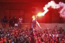 People shout slogans and light flares in front of the U.S. embassy during a protest in Cairo