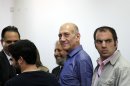 Former Israeli Prime Minister Ehud Olmert stands next to lawyers at Jerusalem's District Court following a verdict hearing in his trial Tuesday, July 10, 2012. An Israeli court on Tuesday cleared Olmert of the major charges in a corruption trial that forced him from power. Olmert was found guilty of a lesser offense, and it was not clear whether that verdict could send him to jail. (AP Photo/Gali Tibbon, Pool)