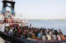 Migrants wait to disembark in the Sicilian harbour of Augusta