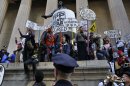Occupy Wall Street protesters stand on the steps of Federal Hall, across the street from the New York Stock Exchange in New York
