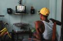 A man watches a report on TV announcing the reestablishment of full diplomatic ties between Cuba and the US, in Havana on July 1, 2015