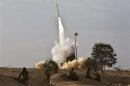 Israeli soldiers watch as an Iron Dome launcher fires an interceptor rocket near Beersheba