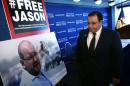 Ali Rezaian looks at a picture of his brother, Washington Post Tehran bureau chief Jason Rezaian, after a news conference at the National Press Club on July 22, 2015 in Washington, DC
