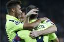 Barcelona's Lionel Messi, partially hidden by teammates, is congratulated by Neymar, left, and Barcelona's Andres Iniesta, right, as they celebrate his sides's first goal during the Champions League Group F soccer match between Paris Saint German and Barcelona at Parc des Princes stadium in Paris, France, Tuesday, Sept. 30, 2014. (AP Photo/Michel Euler)