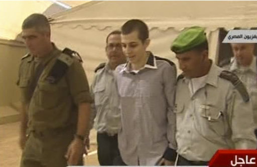 In this image from Egypt TV Tuesday Oct 18 2011 Israeli soldier Gilad Schalit is seen with unidentified military officials at Rafah Terminal on the Egypt- Gaza border.  Schalit was moved to Egypt from captivity in Gaza and then on to Israel in an elaborate prisoner swap deal in which hundreds of Palestinian inmates are to be freed in return for the captured tank crewman who had been held by Hamas for over five years.  (AP Photo/ Egypt TV) TV OUT NO SALES