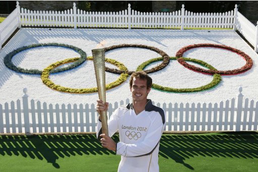 Britain's Andy Murray poses with the Olympic Torch on Murray Mound at the All England Lawn Tennis Club before the start of the London 2012 Olympic Games in London