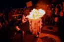 A woman blows fire to a turnstile removed during a joint protest against a rise on public bus fares and the Brazil 2014 FIFA World Cup, in Rio de Janeiro, on February 10, 2014
