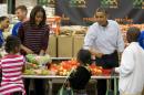 President Barack Obama, right, and first lady Michelle Obama participate in a Thanksgiving service project by handing out food at the Capital Area Food Bank on Wednesday, Nov. 27, 2013 in Washington. The Capital Area Food Bank distributes 30 million pounds of food annually. (AP Photo/ Evan Vucci)