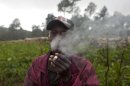 In this picture taken Aug. 16, 2012, vegetable farmer Nevel Dayis smokes a cigarette as he poses for a picture in La Visite National Park, Haiti, a rare piece of protected woodland in one of the most deforested countries on earth. A police operation to clear out farmers living for generations in the national park is now under investigation after four squatters were shot to death in the attempted eviction. (AP Photo/Dieu Nalio Chery)