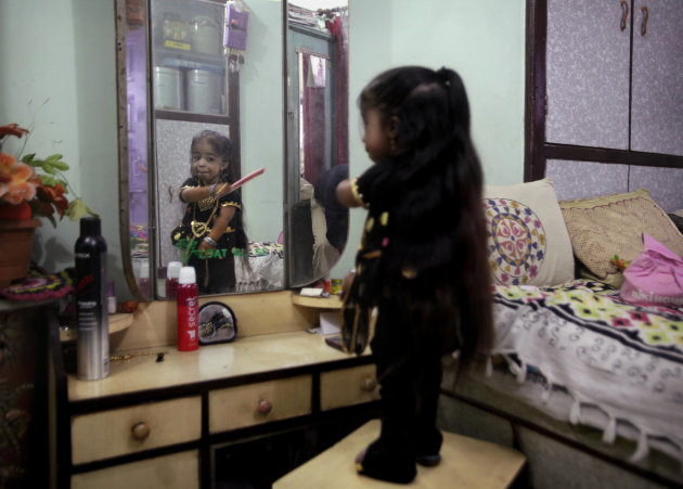 Indian Jyoti Amge, 18, who stands at 61.95 centimeters (2 feet), combs her hair in front of a mirror as she prepares for a press conference with Guinness World Records in Nagpur, India, Friday, Dec. 1