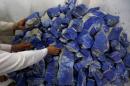 Men sort lapis lazuli inside a shop in Kabul