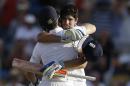 England's captain Alistair Cook celebrates with teammate Jos Buttler, back to camera, after scoring a century against West Indies on day one of their third Test match at the Kensington Oval in Bridgetown, Barbados, Friday, May 1, 2015. (AP Photo/Ricardo Mazalan)