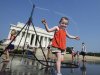 Sophie, 3, from Connecticut, frolics with a water sprinkler set up at the National Mall near the Lincoln Memorial, rear, in Washington Saturday, July 7, 2012.  The heat gripping much of the country is set to peak Saturday in many places, including some Northeast cities, where temperatures close to or surpassing 100 degrees are expected. (AP Photo/Manuel Balce Ceneta)