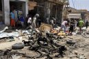 Residents gather at the site of a bomb attack in a market in the eastern Iraqi town of Zubaidiya in Kut