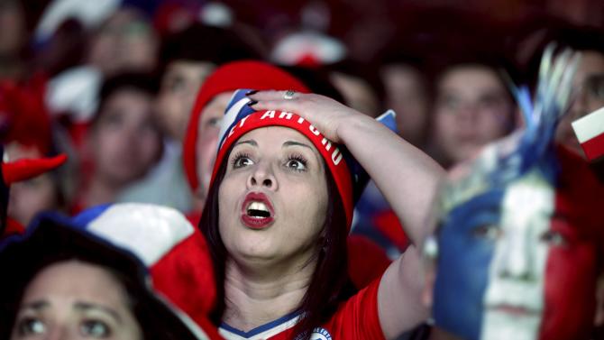 Fans of Chile react while watching a broadcast of the Copa America semi-final soccer match between Chile and Peru at the Fan Fest in Santiago, Chile