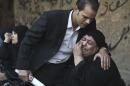 An Egyptian relative of one of the victims of a shooting spree targeting a wedding at a Cairo Coptic Church is comforted as she mourns at a morgue on October 21, 2013
