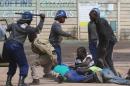 Riot police detain residents of Epworth suburb after a protest by taxi drivers turned violent in Harare