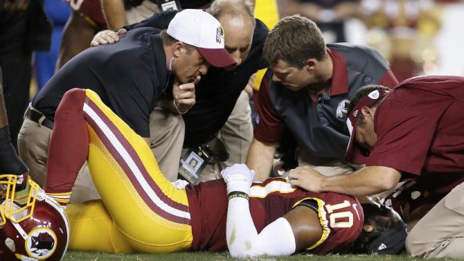 Washington Redskins quarterback Robert Griffin III (10) is examined after an injury during the first half of an NFL preseason football game against the Detroit Lions, Thursday, Aug. 20, 2015, in Landover, Md. (AP Photo/Alex Brandon)