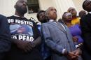FILE - In this Aug. 12, 2014 file photo, civil rights leader Rev. Al Sharpton, center, stands with the parents of Michael Brown, Lesley McSpadden, right, and Michael Brown Sr., left, during a news conference outside the Old Courthouse in St. Louis. Lingering questions about Michael Brown could be answered Wednesday as two news organizations seek the release of any possible juvenile records for the unarmed 18-year-old who was shot by a police officer last month. (AP Photo/Jeff Roberson, File)