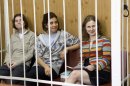 From left, Yekaterina Samutsevich, Nadezhda Tolokonnikova, Maria Alekhina, members of feminist punk group Pussy Riot sit behind bars at a court room in Moscow, Russia, Friday, July 20, 2012. The trial of feminist punk rockers who chanted a "punk prayer" against President Vladimir Putin from a pulpit inside Russia's largest cathedral started in Moscow on Friday amid controversy over the prank that divided devout believers, Kremlin critics and ordinary Russians. (AP Photo/Misha Japaridze)