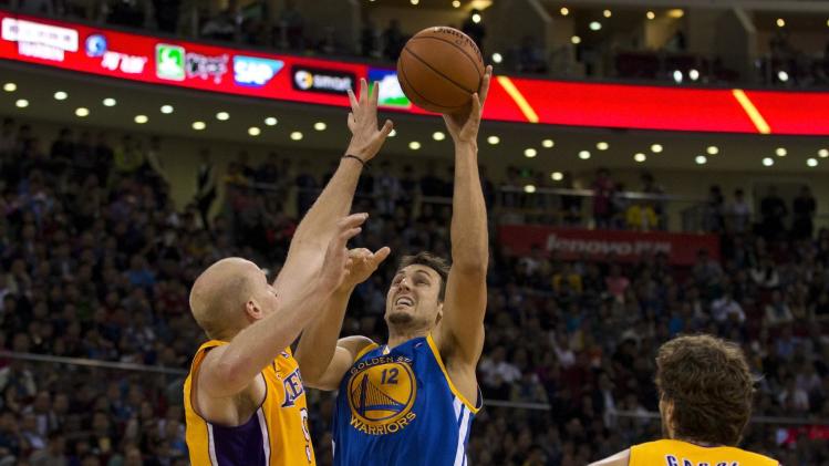 Andrew Bogut of the Golden State Warriors, center, shoots over Chris Kaman of the LA Lakers during their NBA Global Game at the Wukesong Stadium in Beijing Tuesday, Oct. 15, 2013. The Warriors defeated Lakers 100-95