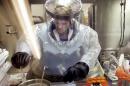 FILE - In this May 11, 2003, file photo, Microbiologist Ruth Bryan works with BG nerve agent simulant in Class III Glove Box in the Life Sciences Test Facility at Dugway Proving Ground, Utah. The specialized airtight enclosure is also used for hands-on work with anthrax and other deadly agents. The Centers for Disease Control and Prevention said it is investigating what the Pentagon called an inadvertent shipment of live anthrax spores to government and commercial laboratories in as many as nine states, as well as one overseas, that expected to receive dead spores. (AP Photo/Douglas C. Pizac, File)