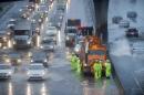 A Caltrans crew tries to clear a flooded stretch of Highway 101 in South San Francisco, Calif., on Thursday, Dec. 11, 2014. A powerful storm churned through Northern California Thursday, knocking out power to tens of thousands and delaying commuters while soaking the region with much-needed rain. (AP Photo/Noah Berger)