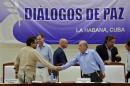 Colombia's lead government negotiator Humberto de la Calle and Colombia's FARC lead negotiator Ivan Marquez shake hands after signing the protocol and timetable for the disarmament of the FARC in Havana