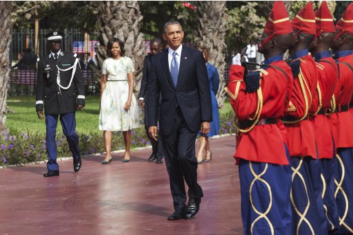 U.S. President Obama inspects an honour guard as first lady Michelle Obama looks on at the presidential palace in Dakar