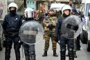Riot police and soldiers stand guard at Place de la Bourse in Brussels on March 27, 2016