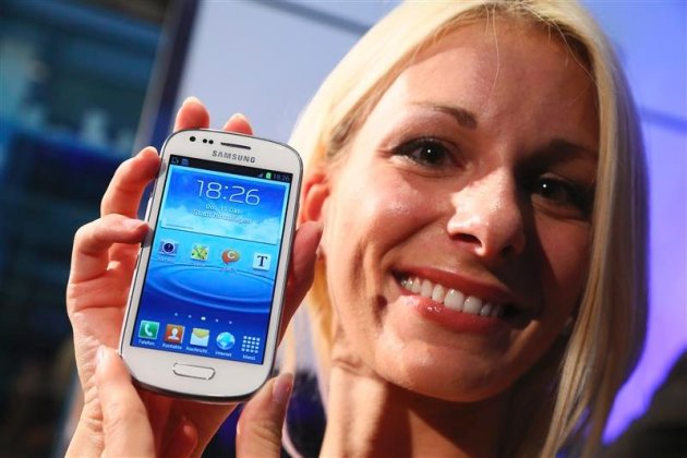 A model displays a Samsung &#39;Galaxy S3 mini&#39; phone during its world premiere in Frankfurt