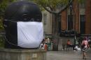 A giant mask on Colombian artist Fernando Botero's sculpture "Cabeza" during a demonstration against air contamination, in Medellin, Colombia, on April 8, 2016